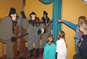 Kinder stehen vor der sogenannten "Affenkapelle": Es sind bewegliche Figuren, die einer Musikgruppe aus Affen aus einem Bilderbuch nachempfunden ist.