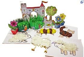Eine Zusammenstellung von vielen Bastelarbeiten aus Papier und Kartonmodellbogen. Zum Beispiel Osternester, Blumentöpfe, ein bemalter Baum aus Papier, zwei Schafe mit Körpern aus Wolle und Beinen aus Schnüren, ein Bild von einem gemalten Schaf, dessen Körper aus Wolle gebildet ist.