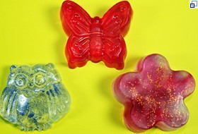 Drei selbstgemachte Seifenstücke in verschiedenen Formen: Blume, Schmetterling, Eule.