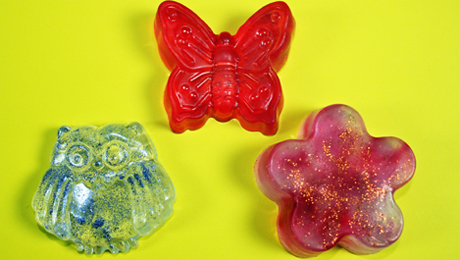 Drei selbstgemachte Seifenstücke in verschiedenen Formen: Blume, Schmetterling, Eule.