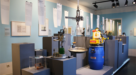 Ausstellungsraum mit vielen Sockeln, auf denen vor allem technische Geräte stehen.