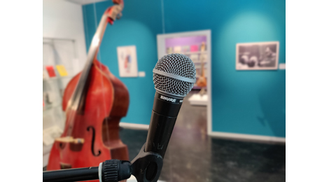 Ein Mikrofon im Ausstellungsraum, dahinter ein Kontrabass.