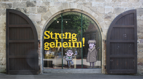 Foto: Großes Fenster des Museums im Schwörhaus mit Beschriftung "Streng geheim!"